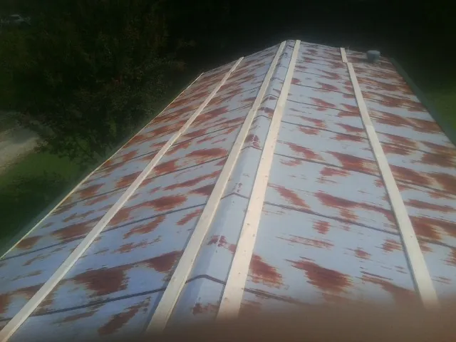 Rusted metal roof panels with new wood purlins before replacement — Storm Damage Roof Repair in Eight Mile by Roofing Brothers