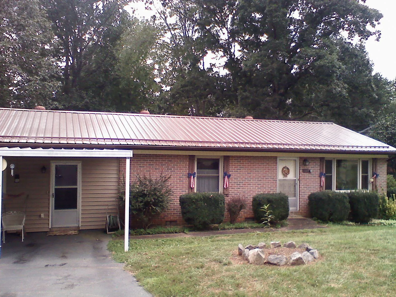 Bronze metal roof and carport on a brick ranch home — Roof Repair work by our crew in Eight Mile